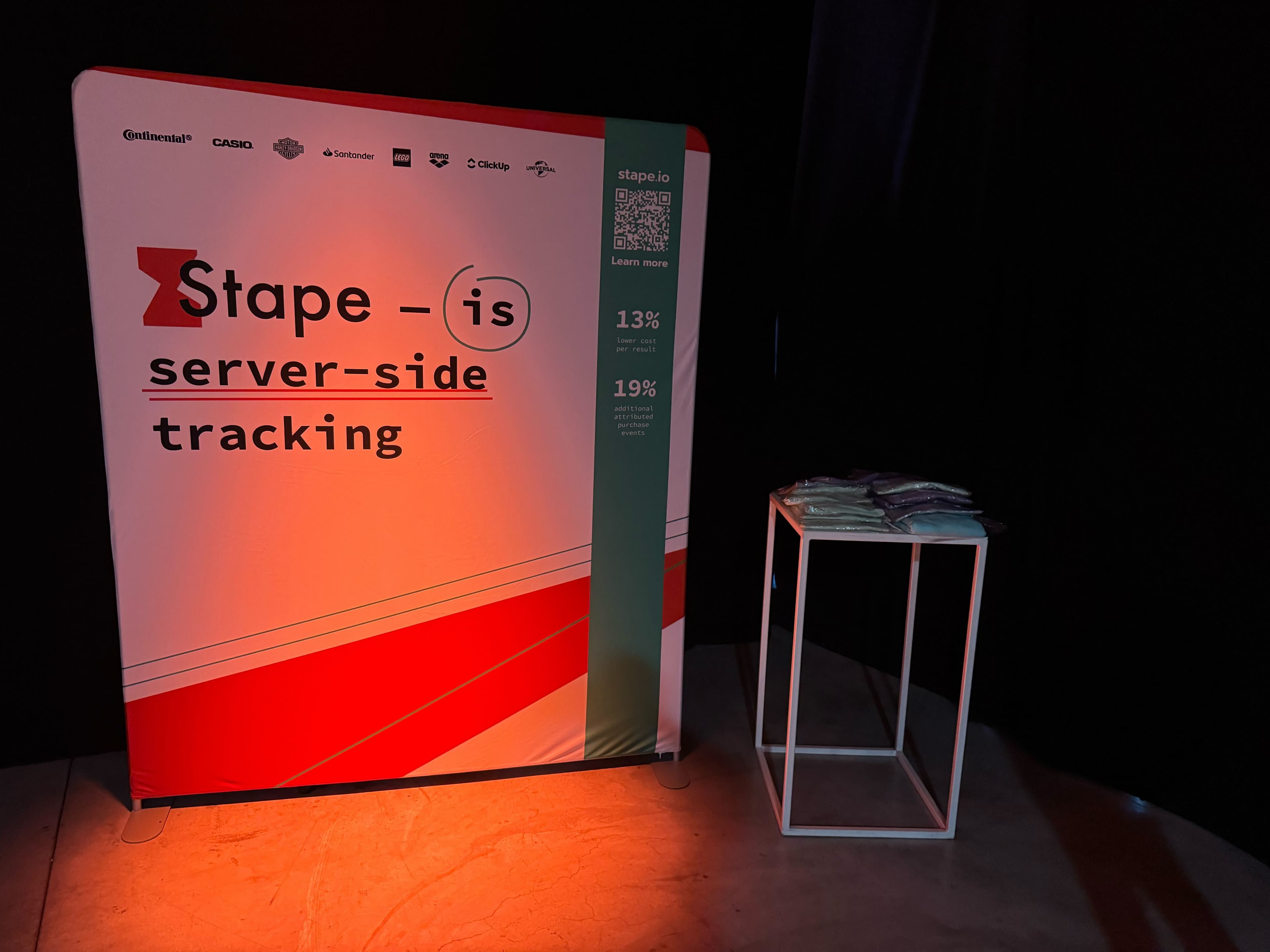 Stape stand at the GA Summit 2025 in Milan, showcasing branding materials and engaging with visitors.
